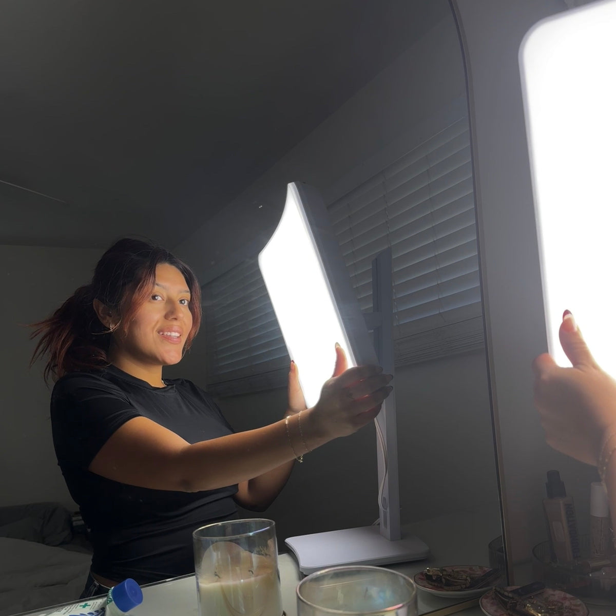 Woman adjusting the angle of the Day-Light Elite Carex light therapy lamp